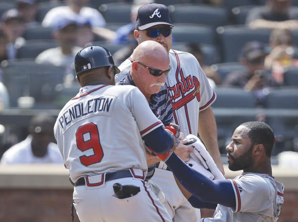 Atlanta's Jason Heyward, right, is helped up after being hit in the face by a pitch against the New York Mets on Wednesday. (Seth Wenig | Associated Press)