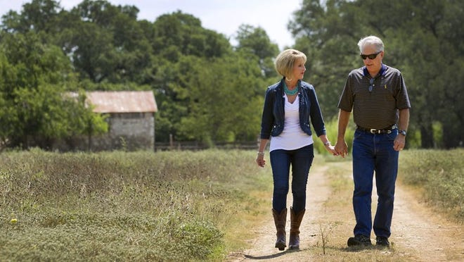 Marci White and her husband, Ron White, walk on the South Austin property that her father, Eli Garza, owned and sought to develop for years.