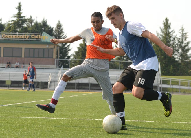 Herkimer County Community College soccer team members Isaiah Kossime, 21, and Daniel Galey, 19, scrimmage during practice at HCCC in Herkimer Wednesday, August 22, 2013.