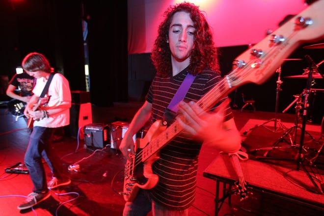 Joey Morrow, right, shown at West Port High School, plays bass in the band Antic.
