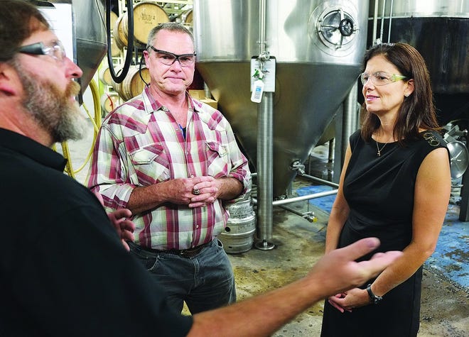 David Yarrington, an executive brewer at Smuttynose Brewing Co., left, and Peter Egleston, Smuttynose president, talk with U.S. Sen. Kelly Ayotte, R-N.H., during a tour of the Portsmouth brewery on Thursday.