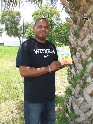 Pastor Christopher Walker, founder of Cathedral of Power International Church of Clermont, and who authored his first book, “Lemons to Lemonade — Overcoming your past and winning in the now,” stands on the lot where an abandoned house once stood where he and his two sons lived when they were homeless.