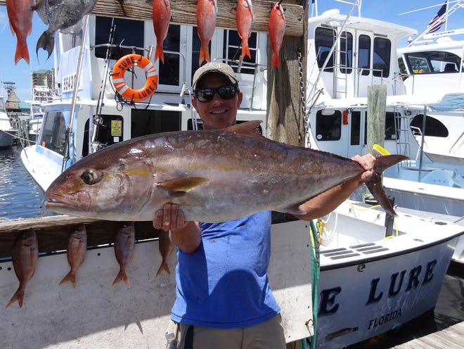 Joe Hawkins of Dallas, Texas shows off a 30-pound “reef donkey” or amberjack he caught last year aboard the Sure Lure.