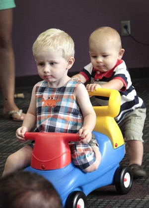 Barrett John, 1, gets a push from Landon Carlisle, 11 months, during a Baby Bounce session at the Edmond Library. PHOTO BY DAVID McDANIEL, THE OKLAHOMAN David McDaniel - The Oklahoman