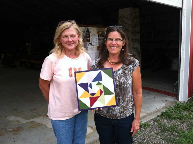 From left, Kansas Flint Hills Quilt Trail committee members Connie Larson, of Alta Vista, and Sue Hageman, of Riley, display the logo of the quilt trail at Ag Heritage Park in Alta Vista. Hageman created the Spinning Star quilt block, which reflects the colors of the Flint Hills.