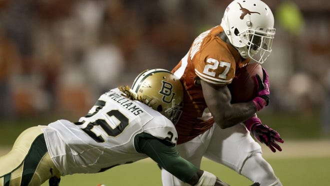 Longhorns running back Daje Johnson is tackled during Texas’ win over Baylor last year. Johnson scored on an 84-yard touchdown run on the first play of the game. Texas and Baylor finish the regular season with each other in Waco this December, in the final game at Floyd Casey Stadium.