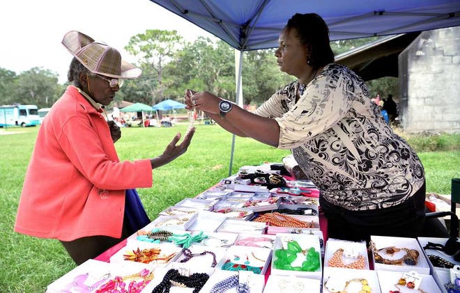 Bruce.Lipsky@jacksonville.com Hyacinth Jackson takes a look at a necklace from Margarita Anderson's Dream Big Designs and Fashion. The monthly Northside Love Arts and Vendors Market, held at Lonnie C. Miller Park on Sunday, usually draws up to 400 visitors, but Sunday's rainy weather held the crowd down.