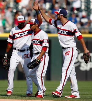 The Chicago White Sox's Alejandro De Aza, left, Leury Garcia, center, and Jordan Danks, right, celebrate after their 5-2 victory over the Texas Rangers in a baseball game on Sunday, Aug. 25, 2013, in Chicago. (AP Photo/Andrew A. Nelles)