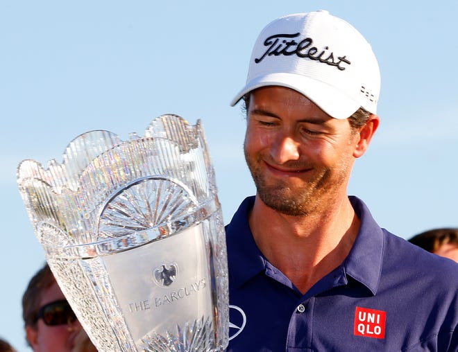 Adam Scott of Australia holds the trophy after winning The Barclays golf tournament on Sunday, Aug. 25, 2013, in Jersey City, N.J.