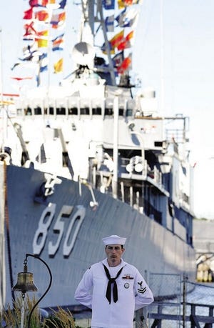 Petty Officer Jonathon Labinski from Warwick, R.I., stands in front of the destroyer Joseph Kennedy during Navy Day festivities at Battleship Cove in Fall River on Saturday.