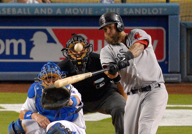 Boston Red Sox's Mike Napoli hits a two-run home run as Los Angeles Dodgers catcher A.J. Ellis and home plate umpire Brian Knight look on during the ninth inning of their baseball game, Sunday, Aug. 25, 2013, in Los Angeles.