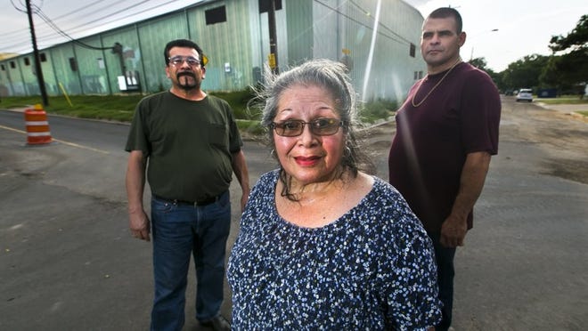 Longtime residents of the Pedernales neighborhood in East Austin are concerned about plans for an apartment complex that would replace a shuttered recycling center. From left, Richard Beltran, Gloria Moreno and Alberto Rendon stand outside of the old Balcones Resources facility.