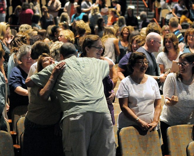 George Massimini of Bristol Township, an autistic support instructional assistant for the Bucks County Intermediate Unit, hugs co-workers Lorna Jackson, left, also of Bristol Township, and Cathy Bayonn of Philadelphia during the IU's opening day program where a speaker told the crowd to tell the person behind them they are "fabulous" on Monday morning at Council Rock High School South.