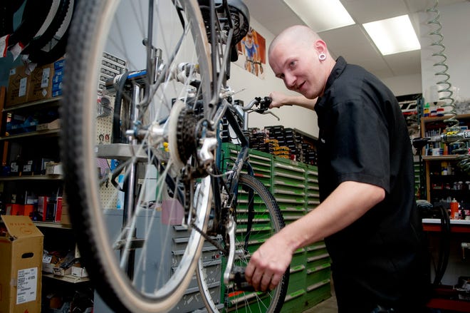 Bicycle technician Robby Hinkle fixes a derailleur on a bicycle on Thursday at Illinois Cycle and Fitness.