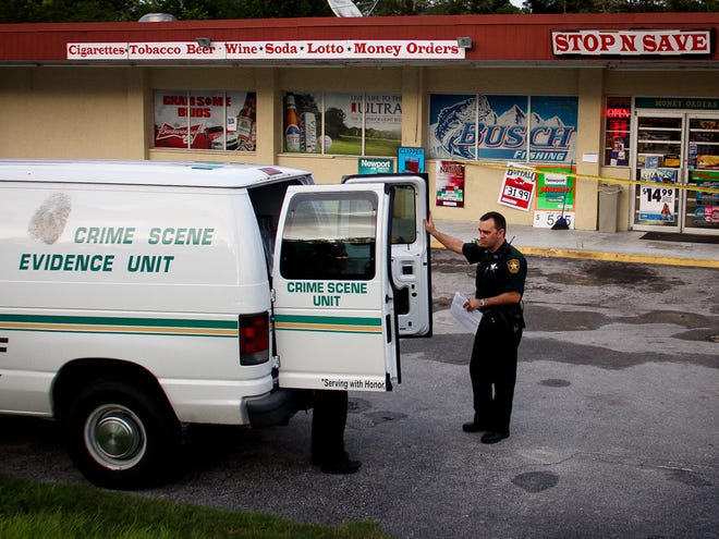 Marion County Sheriff's Office crime scene ttechnicians work at a Stop N Save at the corner of East Fort King Street and Baseline Road after an armed robbery on Sunday.