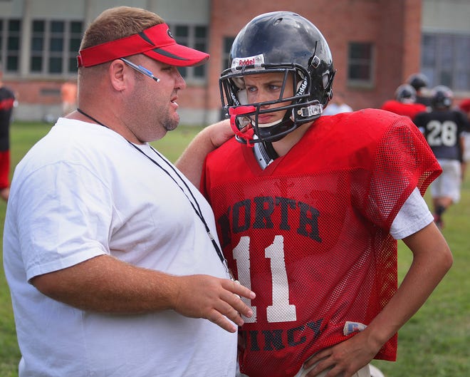Head Coach Mark Nutley has a word with quarterback Joe Fallon during a recent North Quincy High football practice.