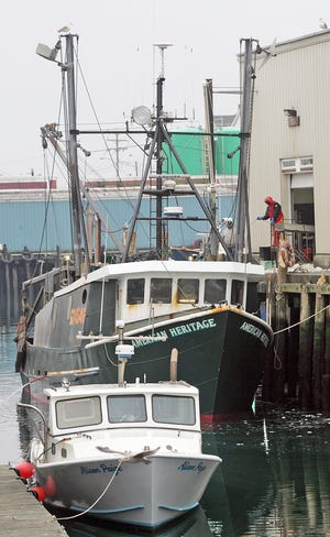 The lobster boat Alison Paige is tied up near the Gloucester House while the F/V American Heritage unloads fish at Fishermen's Wharf on Rogers Street in Gloucester on Wednesday, Feb. 15.
