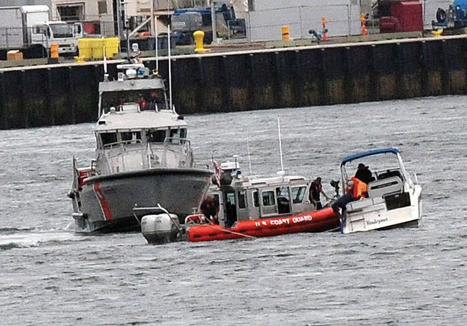 The Coast Guard assists a boat in distress as it travels the Piscataqua River in Portsmouth and here they stop to make some adjustments and eventually pass under the Memorial Bridge shortly after noon on Thursday.