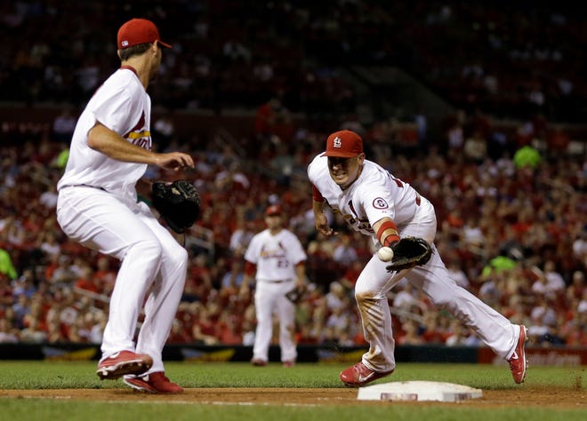 St. Louis Cardinals first baseman Allen Craig, right, flips the ball to pitcher Michael Wacha covering first on a ground out by Cincinnati Reds' Shin-Soo Choo to end the top of the fifth inning of a baseball game Wednesday, Aug. 28, 2013, in St. Louis. (AP Photo/Jeff Roberson)