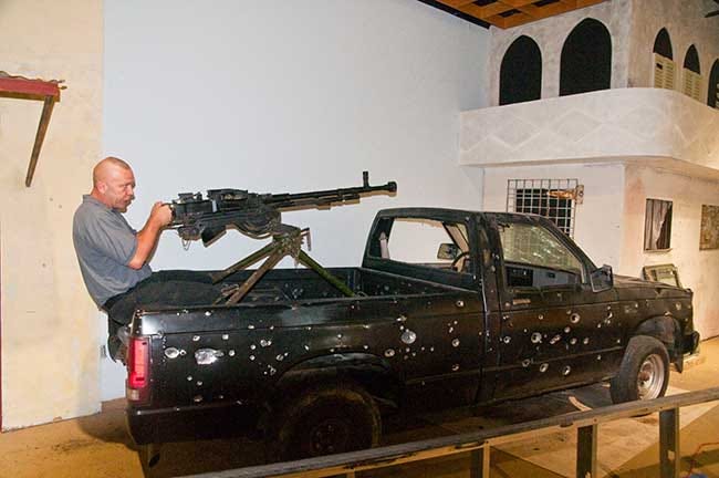 Scott Pelletier, a training and education specialist with the Airborne and Special Operations Museum, adjusts a mounted Soviet heavy machine gun. This type vehicle and weapon was used by warlords in Africa as way to intimidate the local populace.