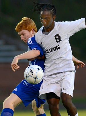 Eastern Guilford's Jason Phipps, left, and Williams High School's Taariq Songster battle for the ball Wednesday night. Although both teams are in the Mid-State 3-A Conference, it was not a conference game.