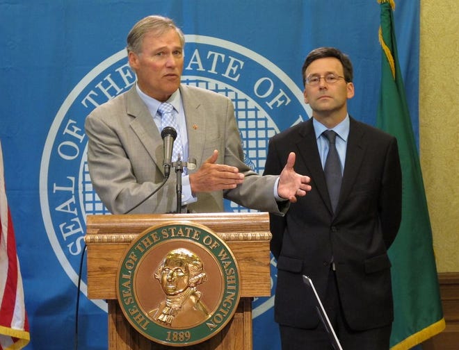 Washington state Gov. Jay Inslee, left, is joined by state Attorney General Bob Ferguson as he talks to the media in Olympia, Wash. about the federal government's announcement Thursday that it will not sue to stop Washington and Colorado from taxing and regulating recreational marijuana for adults.