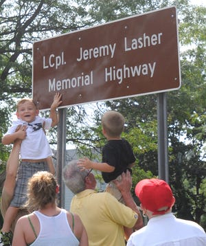 ROB ROTH / OBSERVER-DISPATCH
The son of Jeremy Lasher, Caden, 5, touches the sign honoring his father at the renaming of Route 365A in Oneida in honor of the Marine who died in Afghanistan in 2009.