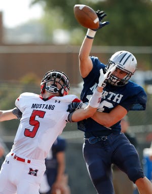 Edmond North's David Wright, at right, breaks up a pass intended for Mustang's Colton Hadlock during a high school football scrimmage at Mustang, Thursday, August 29, 2013. Photo by Bryan Terry, The Oklahoman