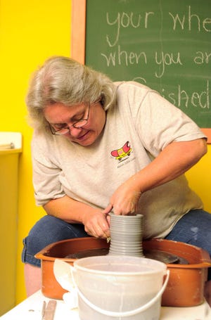 Pat Wobbe stretches the height of her clay pot at Hands on Ceramics.