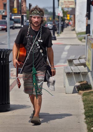 Jon McClister, walking on N. High Street south of Hudson Street, has had an eventful summer. The 27-year-old from Pekin, Ill., came to Ohio last month for the All Good Music Festival in Thornville. He was then left by friends in Columbus. But it's not all bad: He's made new friends, who gave him clothes and a guitar, and he says he likes it so much here that he just might stay.