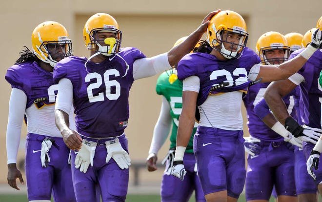 LSU safety Craig Loston (6) watches LSU safety Ronald Martin (26) pat the helmet of LSU cornerback Jalen Collins during drills at McClendon Practice Facility in Baton Rouge, La.