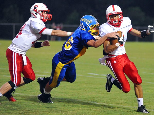 Collinsville’s Jordan Leath tries to evade the tackle of Coosa’s Jace Mills during Friday night’s game in Gadsden. Collinsville quarterback Tanner Nelson, left, was flagged for a hold on the play.