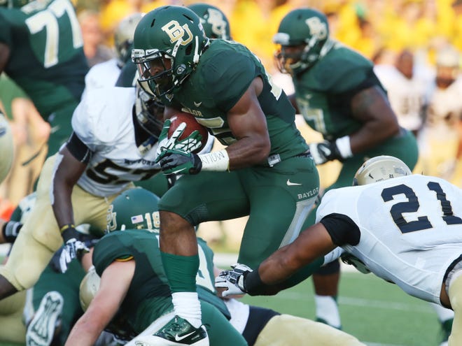 Baylor Bears running back Lache Seastrunk, center, scores past Wofford linebacker Travis Thomas (21), right, during the first half of an NCAA college football game on Saturday, Aug. 31, 2013, in Waco, Texas. (AP Photo/Waco Tribune Herald, Rod Aydelotte)