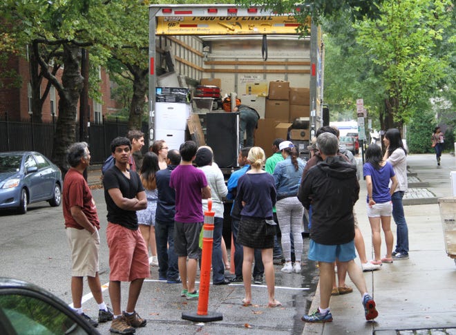Sameer Sarkar, second from left, a sophomore from Richmond, Va., waits for his boxes to be unloaded from a truck Sunday on Thayer Street. The truck was carrying the possessions of about 25 Brown students.