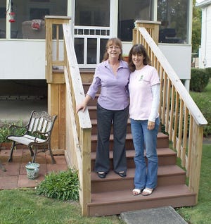 Patti Pickles and Lisa Novitsky stand on Pickles' new back porch. Novitsky works for Community Progress Inc., which provided Pickles with grant money to make repairs to her Painted Post home, including new front and back steps.