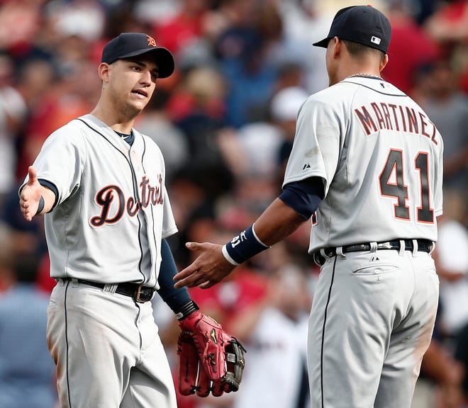 Detroit's Jose Iglesias and Victor Martinez, both former Red Sox players, celebrate after the Tigers' 3-0 win over Boston on Monday at Fenway Park.