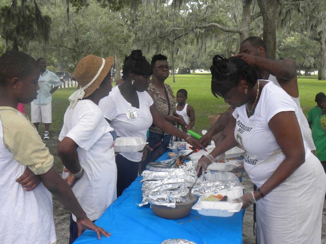 Attendees of the "Piccolo" Day community-wide picnic Monday in Daffin park are served food. (Dash Coleman/Savannah Morning News)