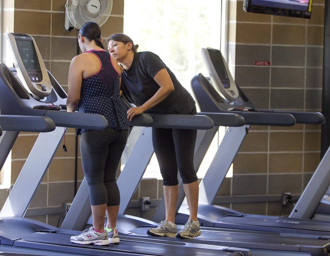 Paula Marks, right, and her sister, Lori Acosta, 38, exercise on the treadmills of the YMCA Communities Branch in Austin, Texas. Paula spends as much quality time taking Lori, who is diagnosed with early-onset Alzheimer's disease, out on daily errands to exercise, shop, and eat out.