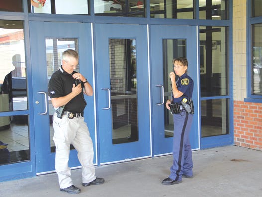 Dan Kinner of the Chippewa County Sheriff Office and Ailene Bitnar of the Michigan State Police secured the perimeter of the Sault High School on Tuesday after a bomb threat marred the opening day of school. Authorities evacuated nearly 1,000 students and staff while they conducted a search of the structure to ensure there were no explosives inside the building.