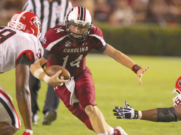 South Carolina quarterback Connor Shaw runs with the ball while avoiding Georgia's Jordan Jenkins, left, and Garrison Smith in Columbia, S.C., on Oct. 6, 2012. The teams play again Saturday in what is the SEC's premier game of the week. (Mark Humphrey | Associated Press)