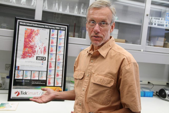 Prof. Thomas Mather, director of URI's Center for Vector-Borne Disease, who researches ticks, in his lab with maps of Rhode Island's deer tick population.