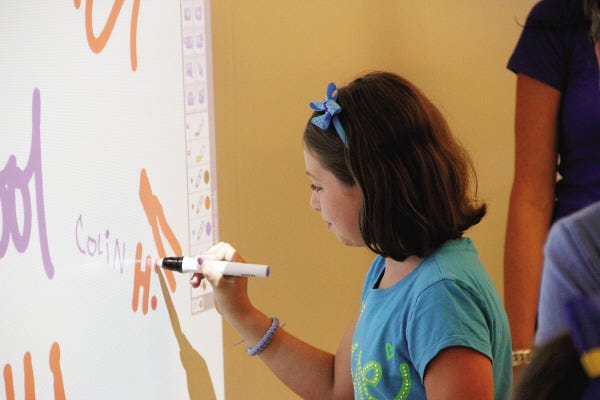 Jayda Picard, who is entering the fifth grade at the Wood School, works on the smart board.