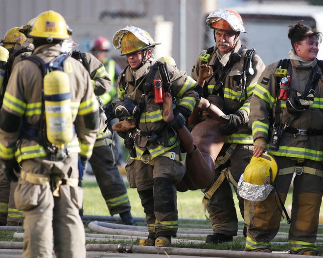 Firefighters carry a dummy out of a burning building during live fire training exercises in Panama City on Thursday.