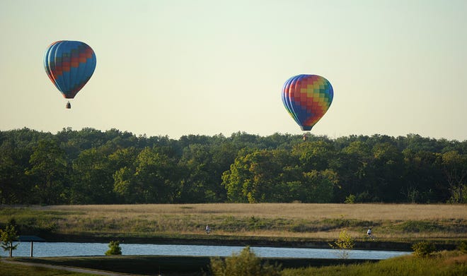 Hot air balloons drift north over Phillips Lake yesterday after departing from Tolton High Scool south of Columbia. Don Shrubshell/Tribune Sept. 2013/Sports/Football-Tolton-S.Boone