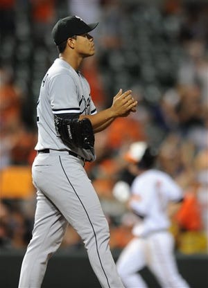 Chicago White Sox pitcher Jose Quintana walks to the mound after giving up a solo home run to Baltimore Orioles' J.J. Hardy, behind, in the fifth inning of a baseball game, Thursday, Sept. 5, 2013, in Baltimore.