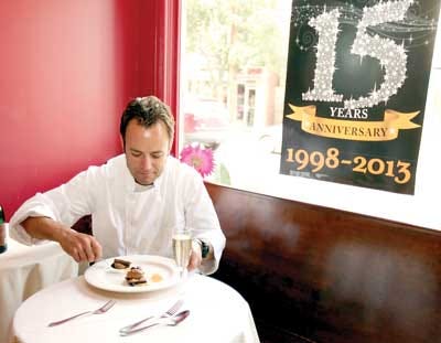 Photo by Tracy Klimek/New Jersey Herald Chef Andre deWaal sits at one of the tables at Andre’s Restaurant on Spring Street in Newton to scoop up a bite of chocolate pavé, one of his creations that will be served as dessert on Sunday.
