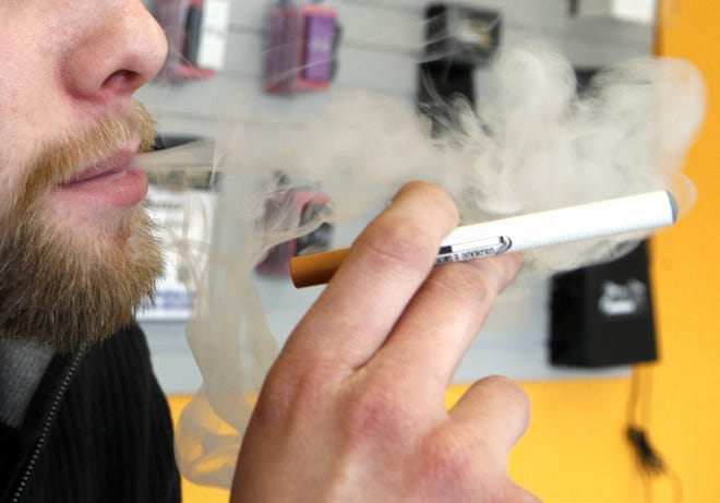A sales associate demonstrates the use of a electronic cigarette and the smokelike vapor that comes from it in Aurora, Colo., on March 2, 2011. (AP Photo/Ed Andrieski) Ed Andrieski