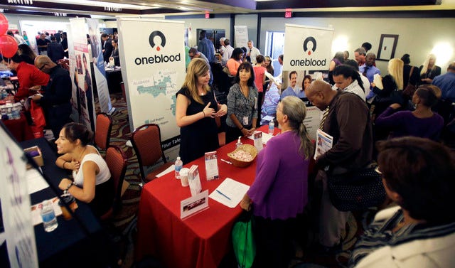 ASSOCIATED PRESS FILE PHOTO / People check out opportunities during a job fair in Miami Lakes, Fla., on Aug. 14.