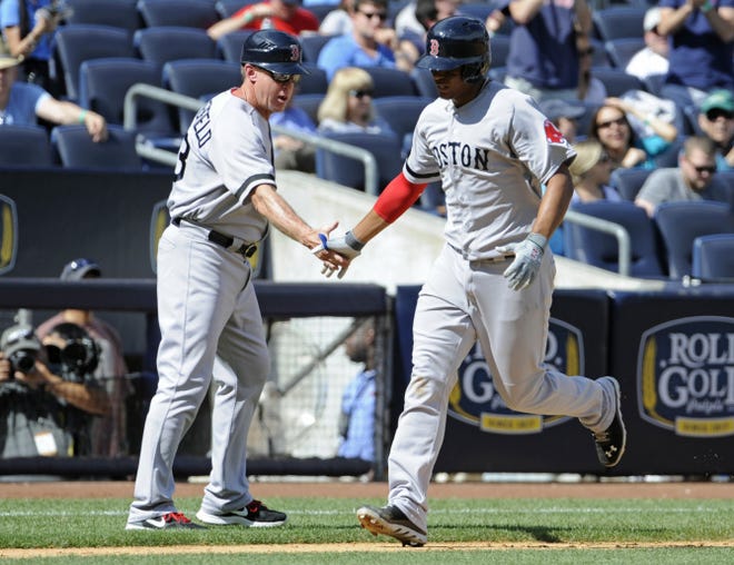 Boston rookie Xander Bogaerts is congratulated by third-base coach Brian Butterfield after belting a 423-foot, two-run homer during the fifth inning of Saturday’s game at Yankee Stadium.