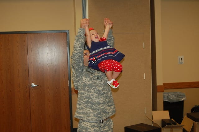 STACY RYBURN • TIMES RECORD / Sgt. Brady Zweifel of Vilonia playfully swings his 18-month-old daughter, Harper, after a Freedom Salute ceremony held Sunday at the University of the Ozarks SEAY Student Center in Clarksville. Zweifel returned home in June after a nine-month mission in Afghanistan with the 39th Brigade Special Troops Battalion of the Arkansas Army National Guard.